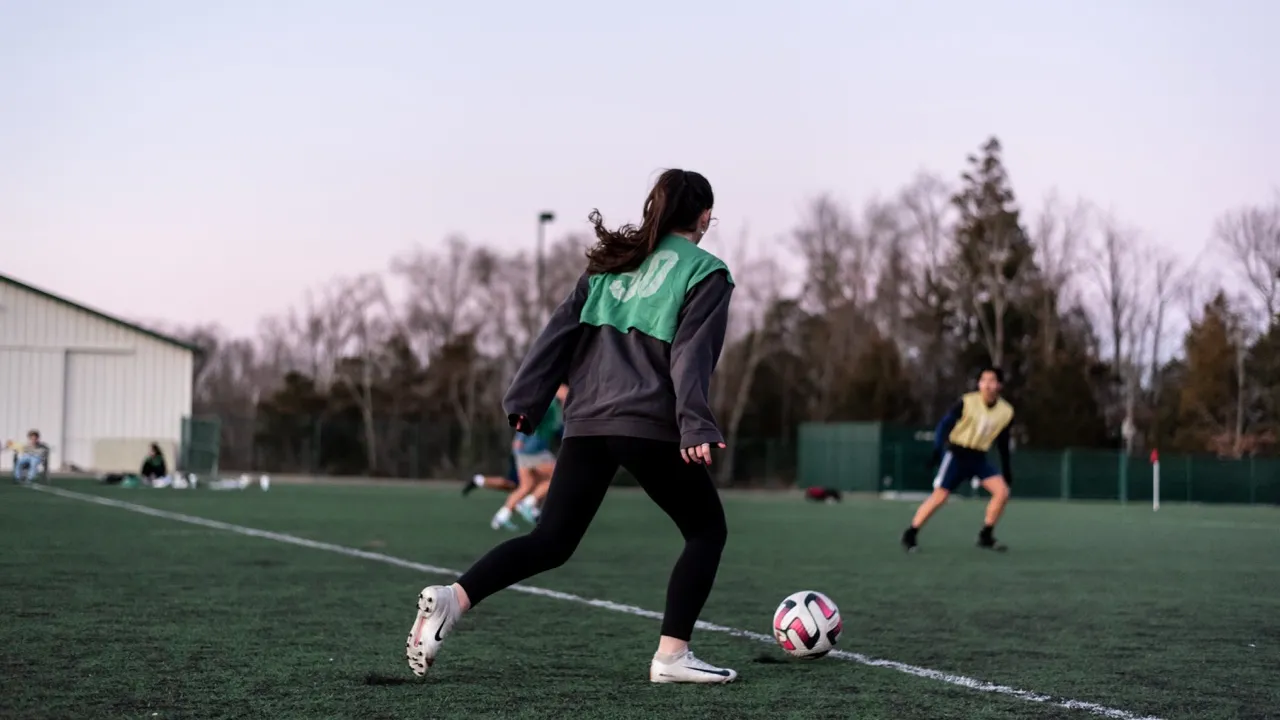 girl playing soccer on field